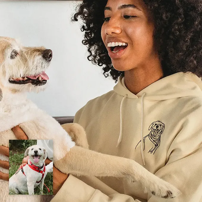 a woman holding a white dog and smiling