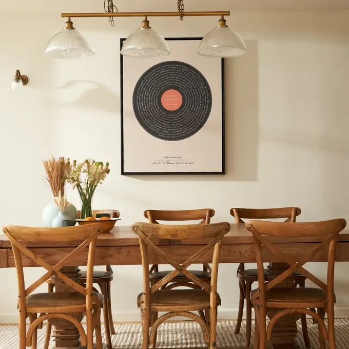 a dining room table with chairs and a picture on the wall