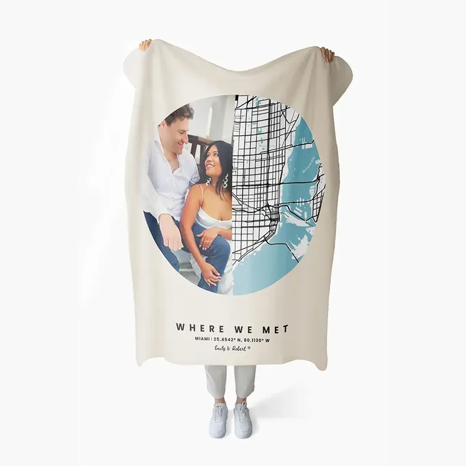 a man and woman holding up a white towel with a picture of a man and