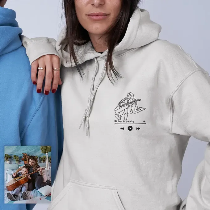 a woman wearing a white hoodie with a picture of a man on it