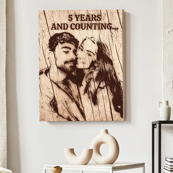 a picture of a couple kissing on a wooden sign