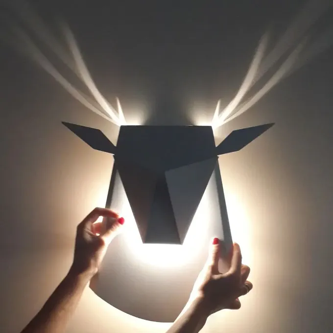 a person is holding a light that is shaped like a deer