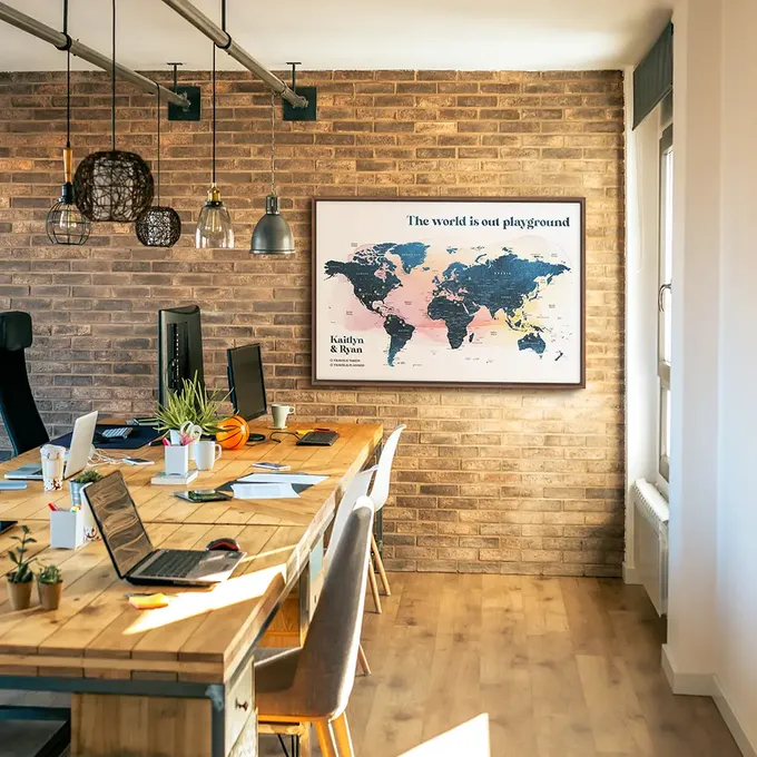 a table with a laptop on it in front of a brick wall