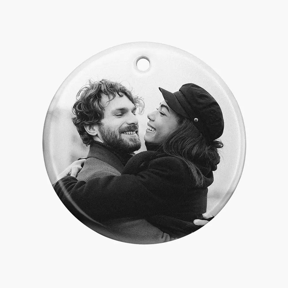 a black and white photo of a man and a woman on xmas ornament