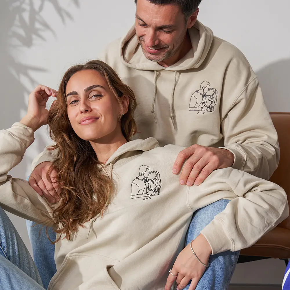 a man sitting next to a woman on a couch with custom hoodie