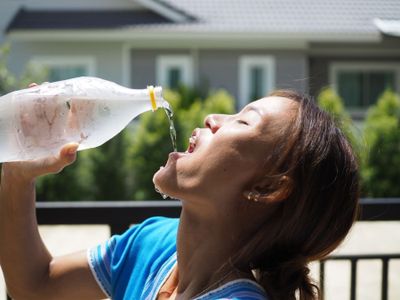 Woman drinking from plastic bottle 