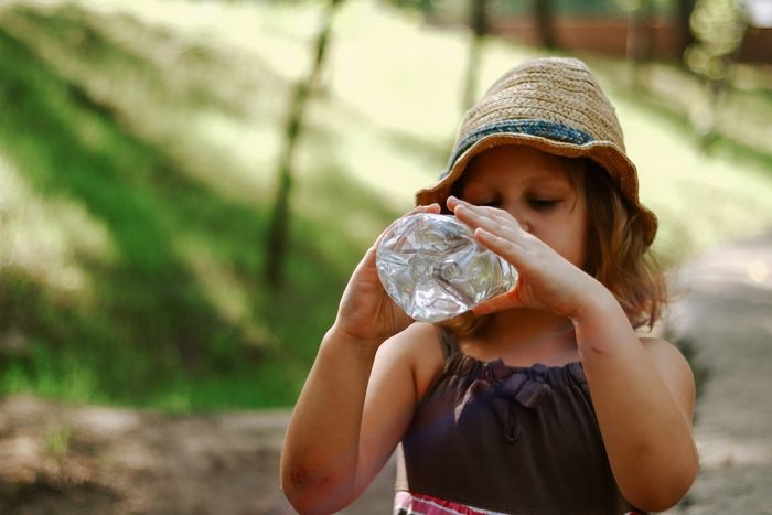 Child drinking water from a plastic bottle