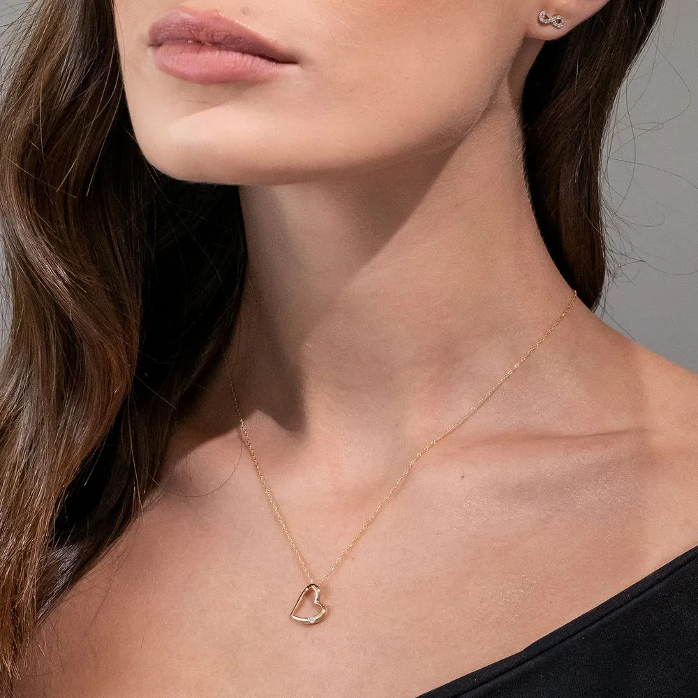Woman wearing a 10K Gold Hanging Heart Pendant Necklace with Diamond