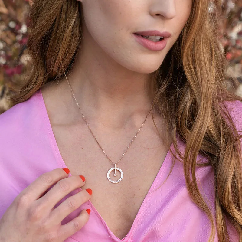 Woman wearing a rose gold plated necklace with a circle pendant 