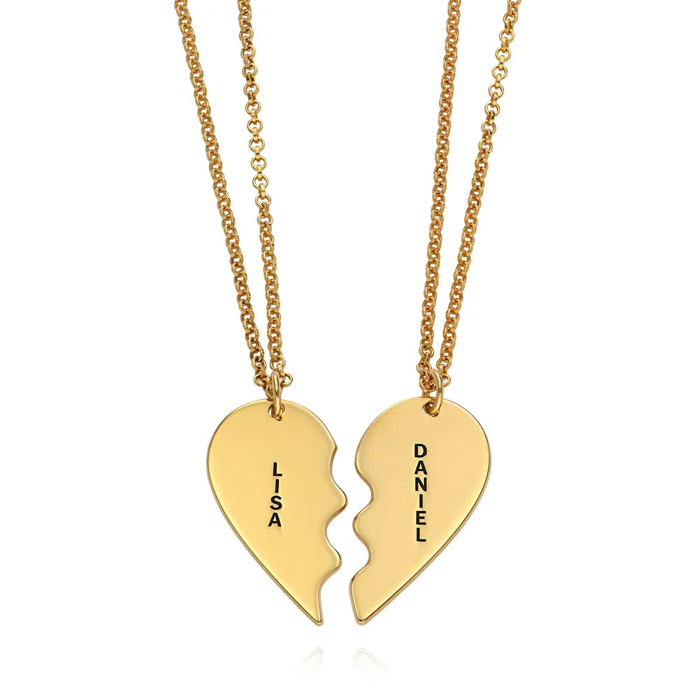 Stock image of two gold plated necklaces with  inscribed matching heart-halves 