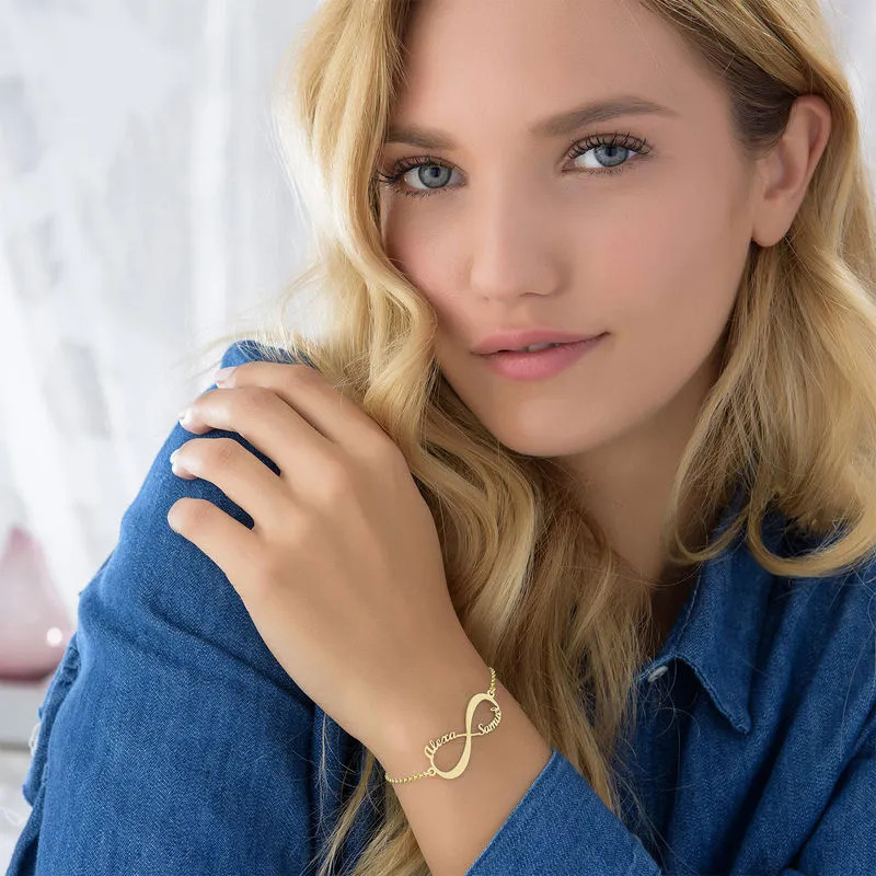 Woman wearing a gold plated infinity bracelet with engraving 