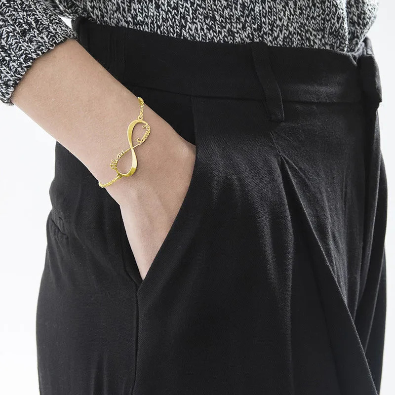 A woman wearing a gold plated infinity bracelet on her wrist  