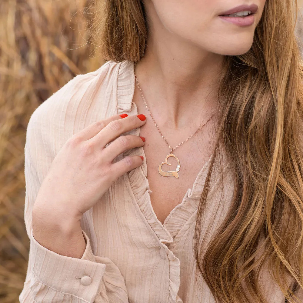 Woman wearing a a rose gold plated necklace with a heart shaped pendant 