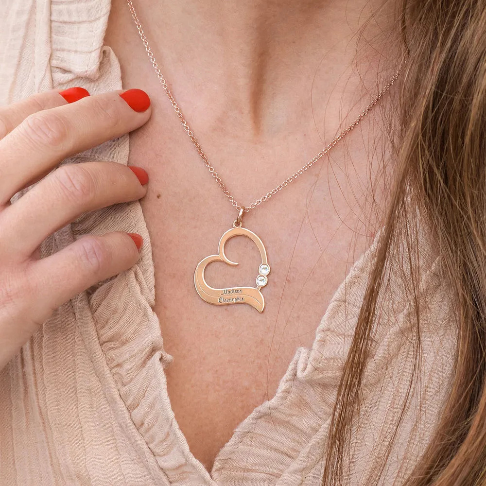 Woman wearing a rose gold plated necklace with a heart shaped pendant 