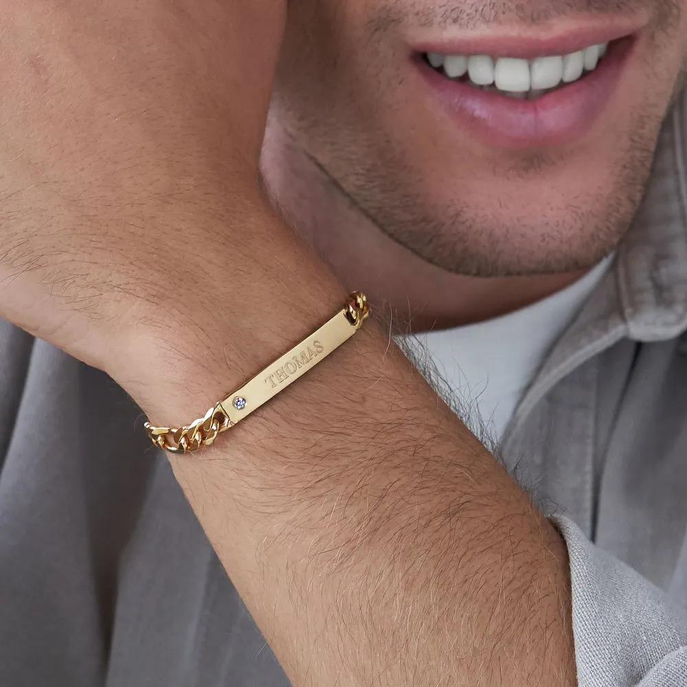 Man wearing a gold bracelet with an inscription 