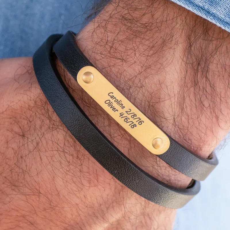 Man wearing a black leather bracelet with a gold plated engraving bar 