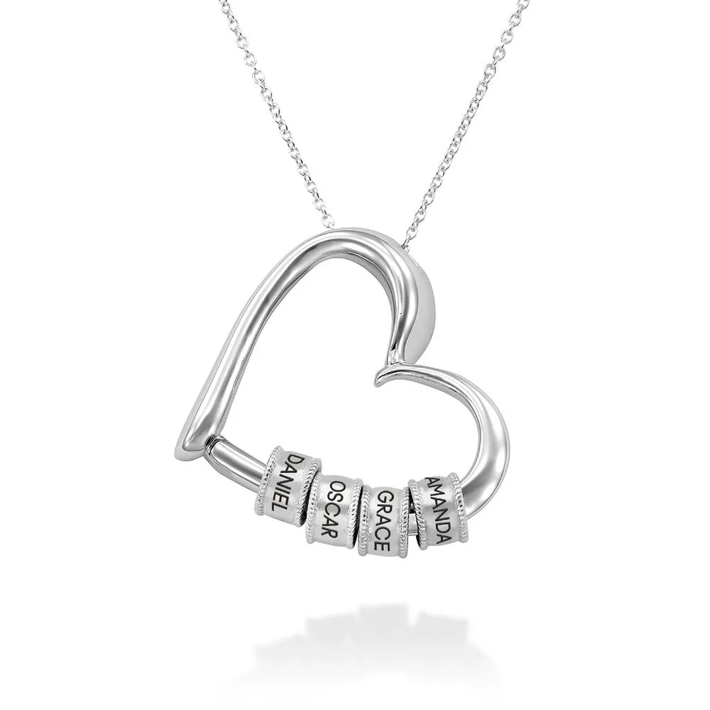 Stock image of a silver necklace with a heart-shaped pendant with inscribed beads