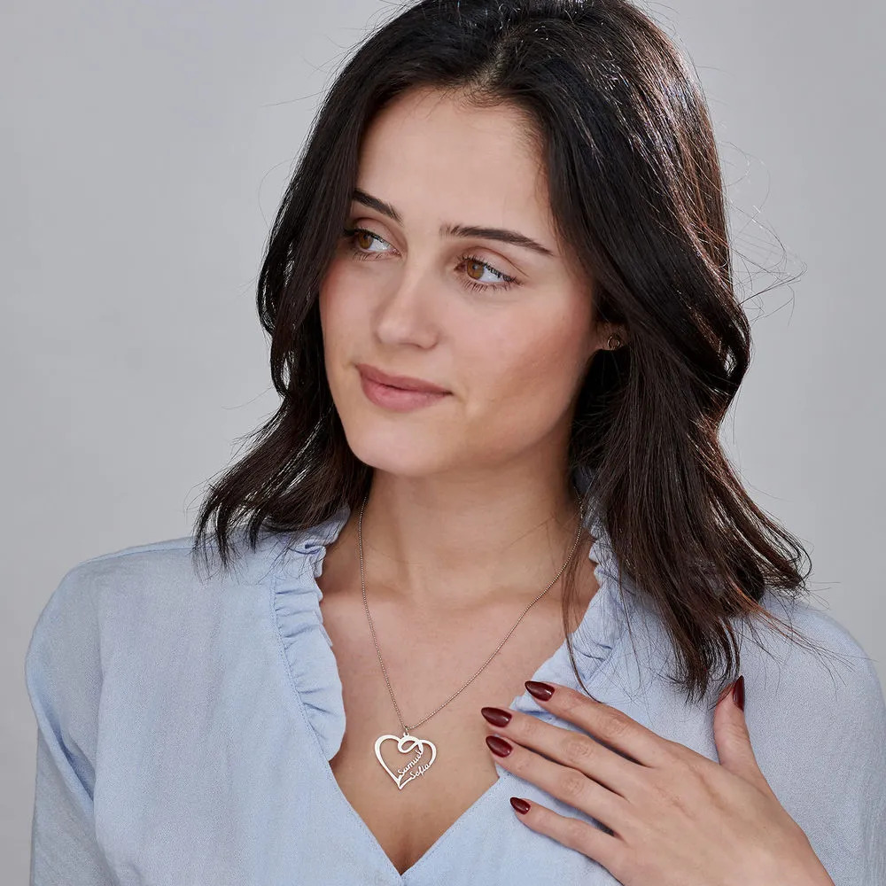 Woman wearing a white gold necklace with a heart shaped pendant 