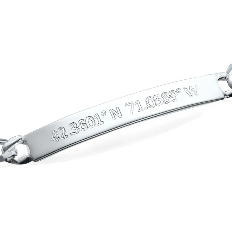 A silver bracelet bar with location coordinates