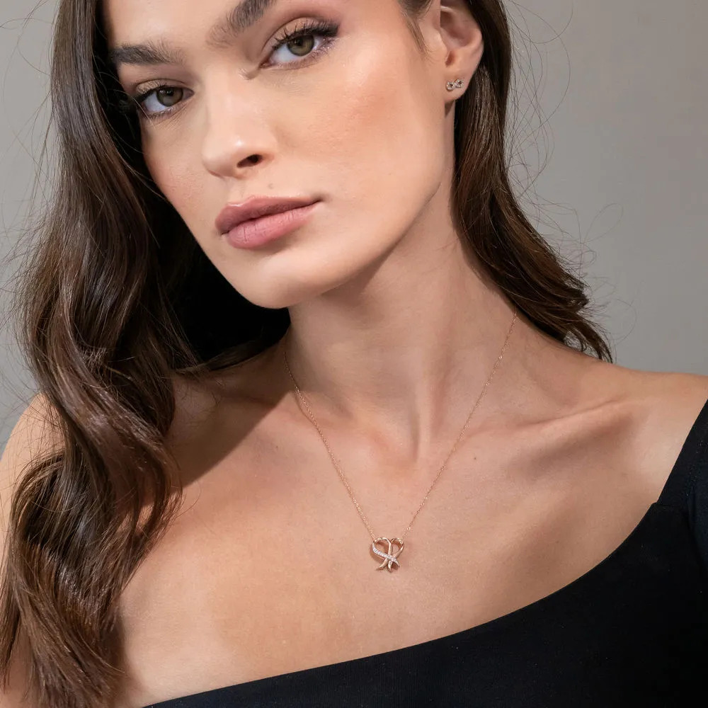 Woman wearing a Rose gold necklace with a diamond covered heart shaped pendant