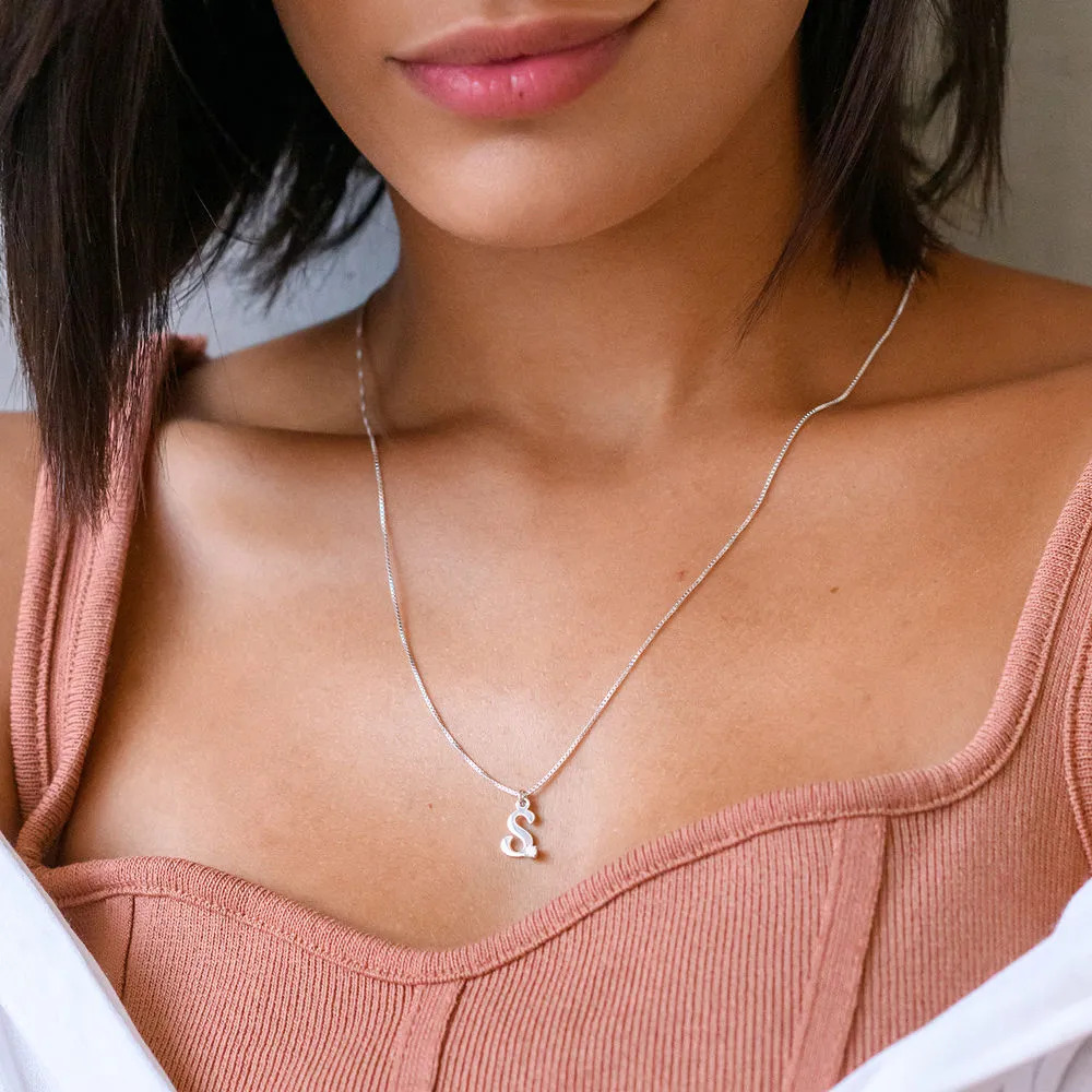 Close up on a woman wearing a sterling silver necklace with a diamond initial 