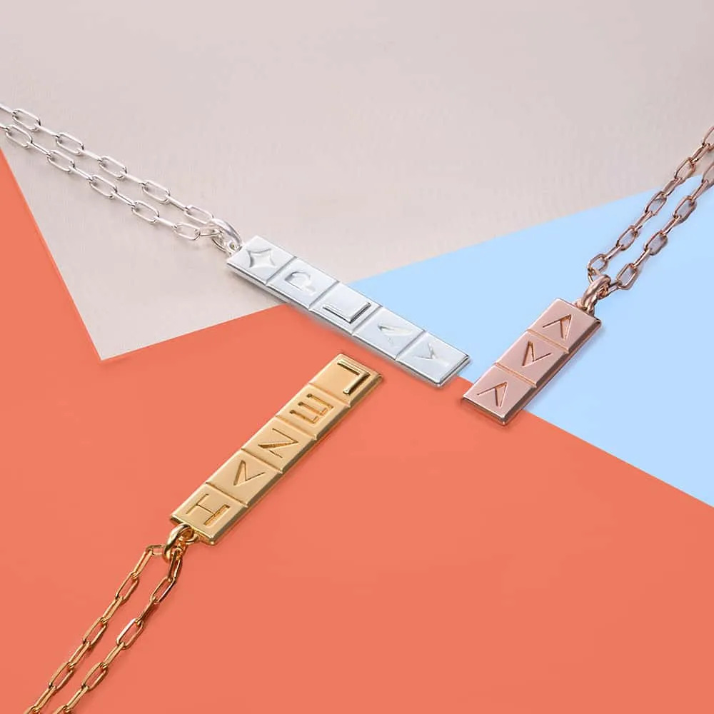 Stock image of vertical tile necklaces in gold, silver and rose gold 