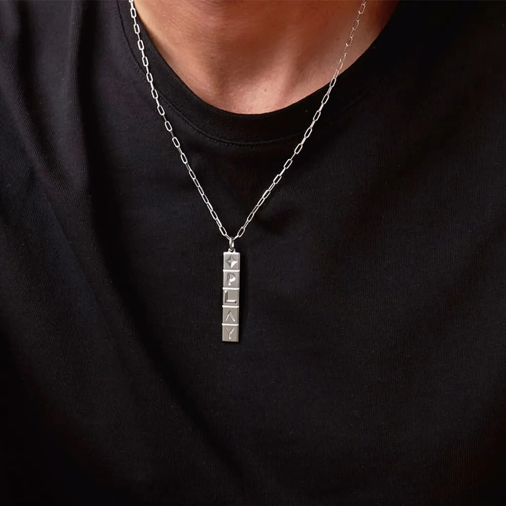 A man wearing a sterling silver necklace with a vertical tile pendant 
