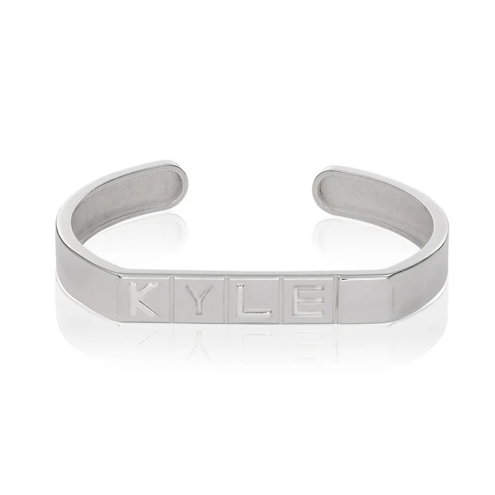 A sterling silver wrist cuff with domino tile shaped initials