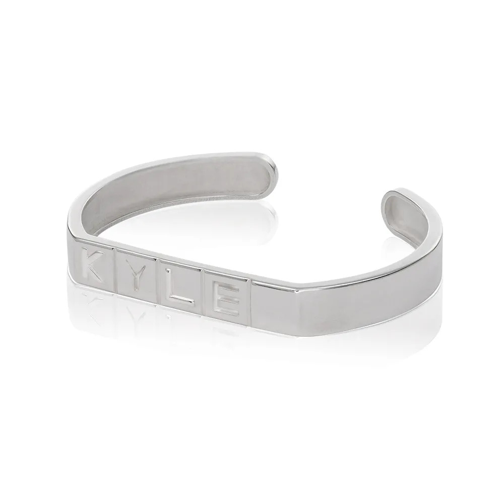 A sterling silver wrist cuff with domino tile shaped initials