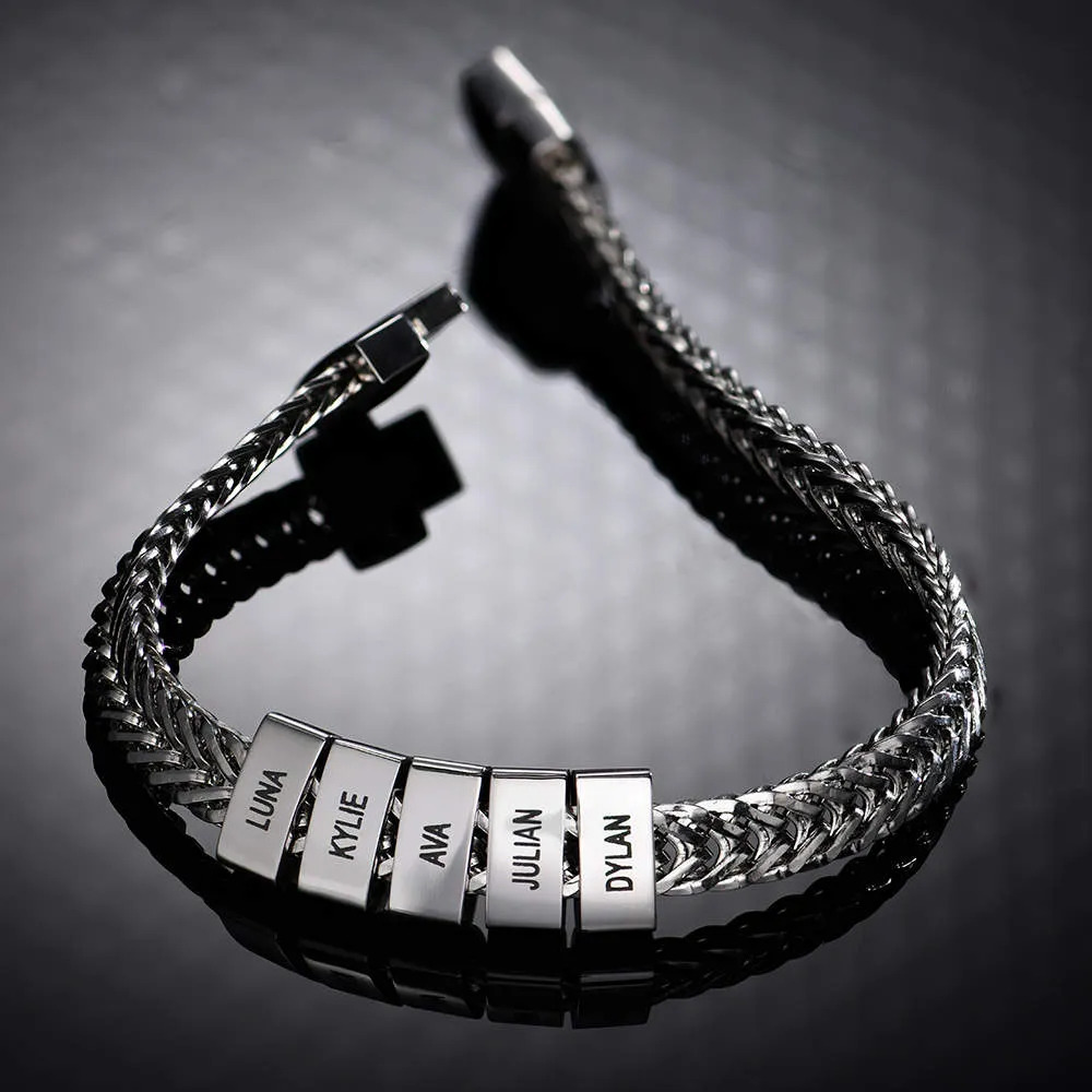 Stock image of a stainless steel bracelet with a locking clasp and  inscribed charms 