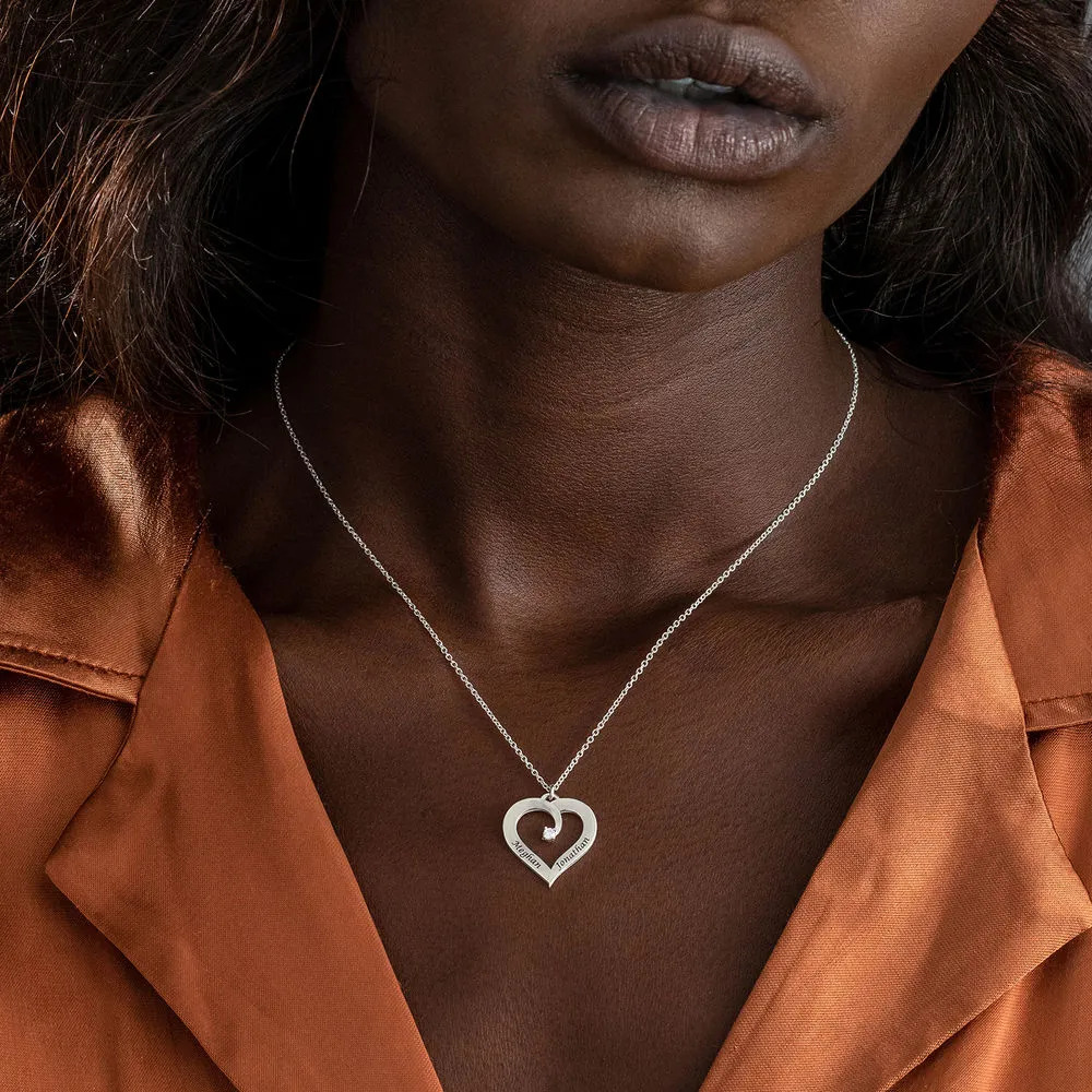 Woman wearing a silver necklace with a heart-shaped pendant 