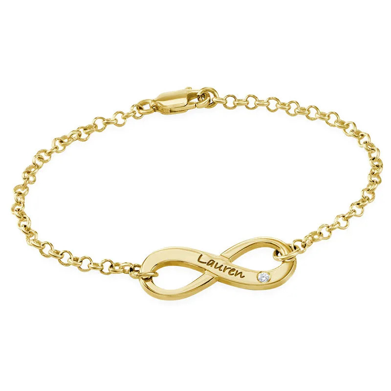 Stock image of a gold plated engraved infinity bracelet with diamond 