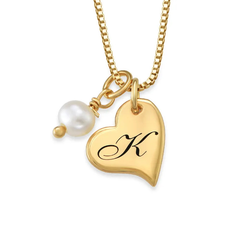 A gold plated necklace with a heart shaped pendant engraved with an initial  and a pearl 