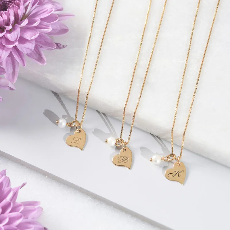Gold plated necklaces with a heart shaped pendant engraved with an initial  and a pearl 