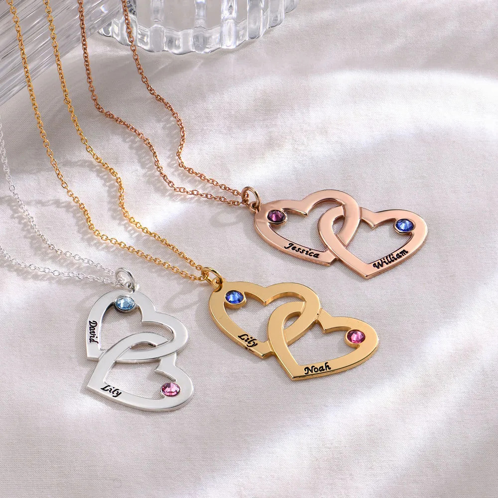 A gold plated necklace with interlocking heart pendants with birthstones