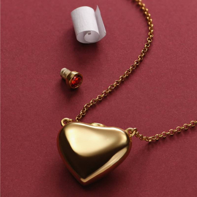 Love Note Puffy Heart Necklace in Gold a gold heart shaped pendant with a roll of toilet paper