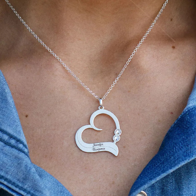 Woman wearing a silver necklace with a personalized heart shaped pendant 