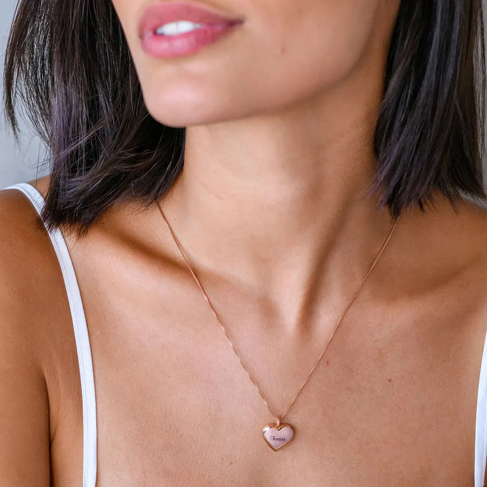 Woman wearing a rose gold heart shaped pendant with engraving 
