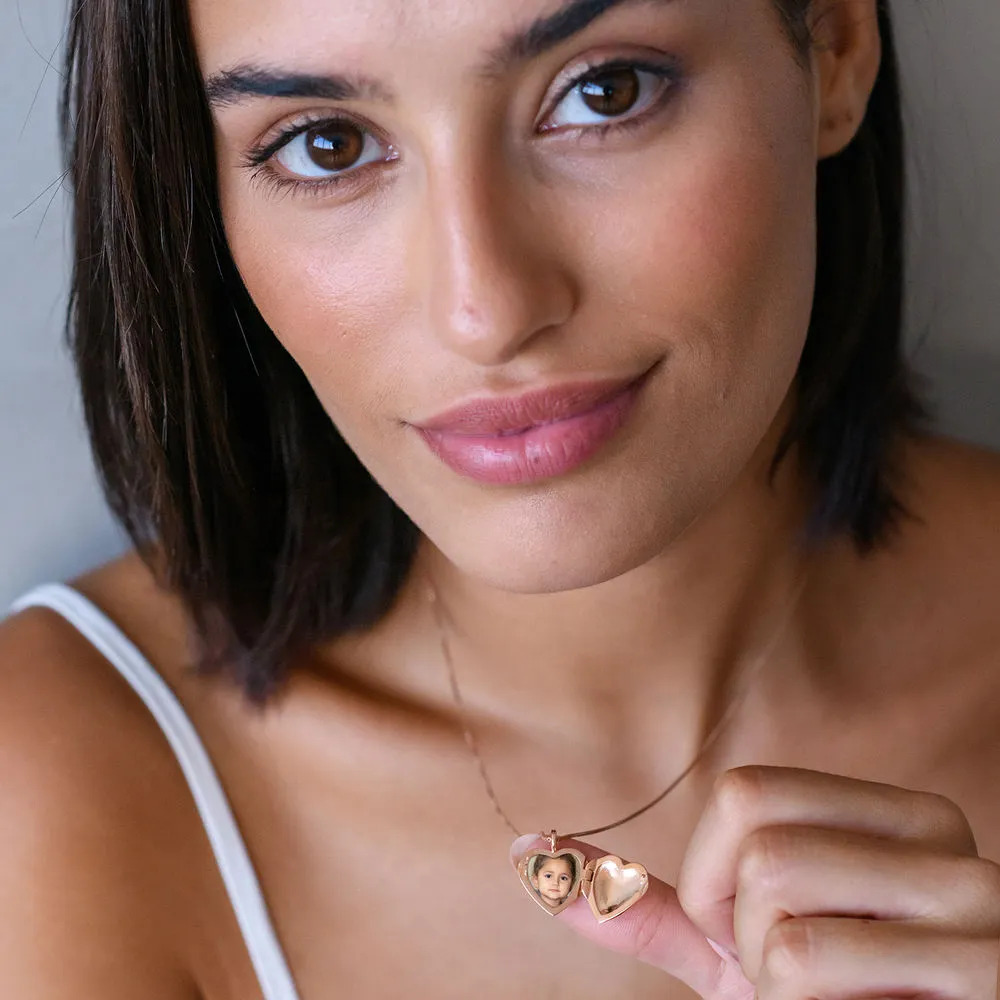Woman wearing a rose gold heart shaped pendant with engraving 