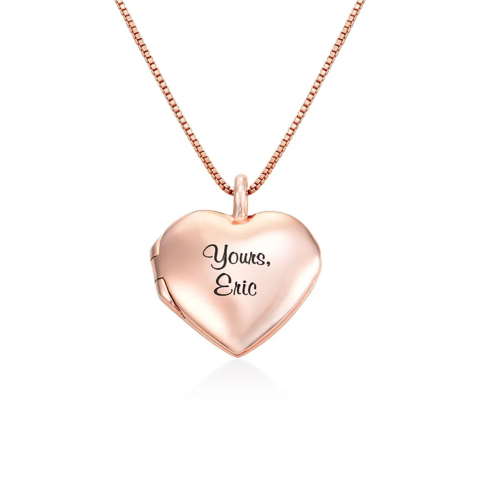A rose gold necklace with heart shaped pendant with an engraving 