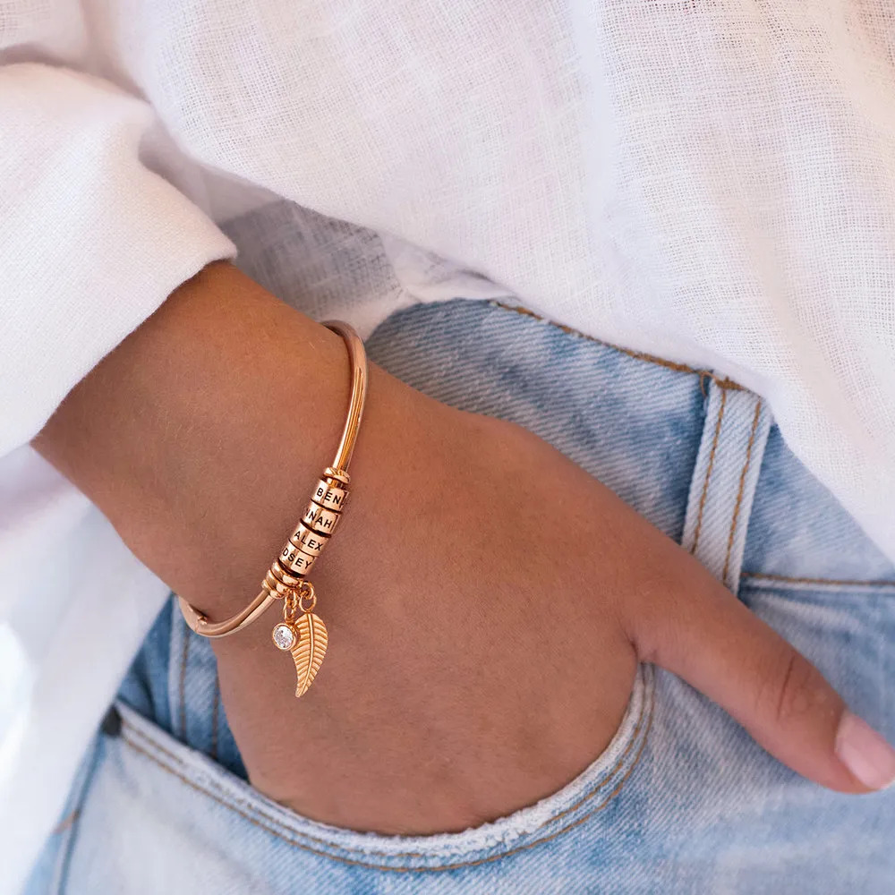 Woman wearing a rose-gold plated bangle bracelet on her wrist 