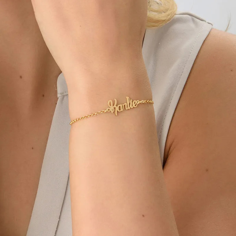 A woman wearing a tiny bracelet with a name inscription 