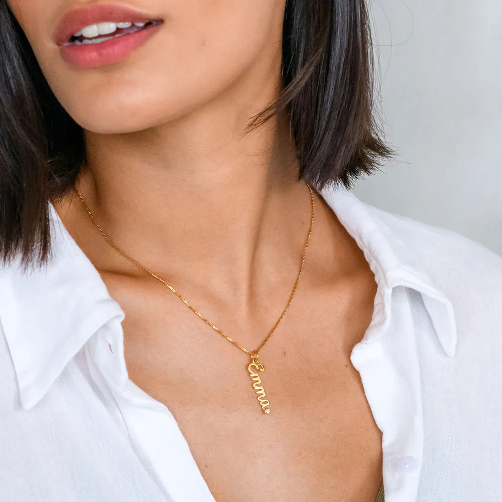Woman wearing a gold plated necklace with a diamond name pendant in cursive 