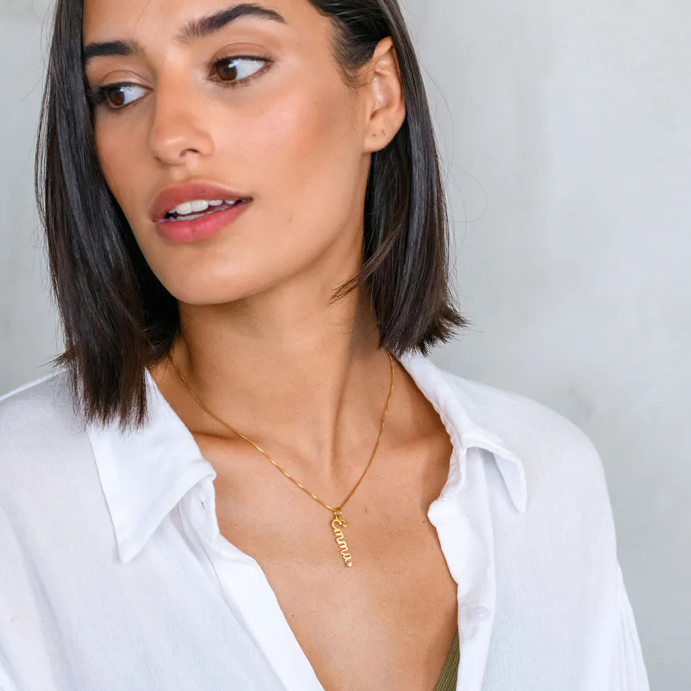 Woman wearing a gold plated necklace with a diamond name pendant in cursive 