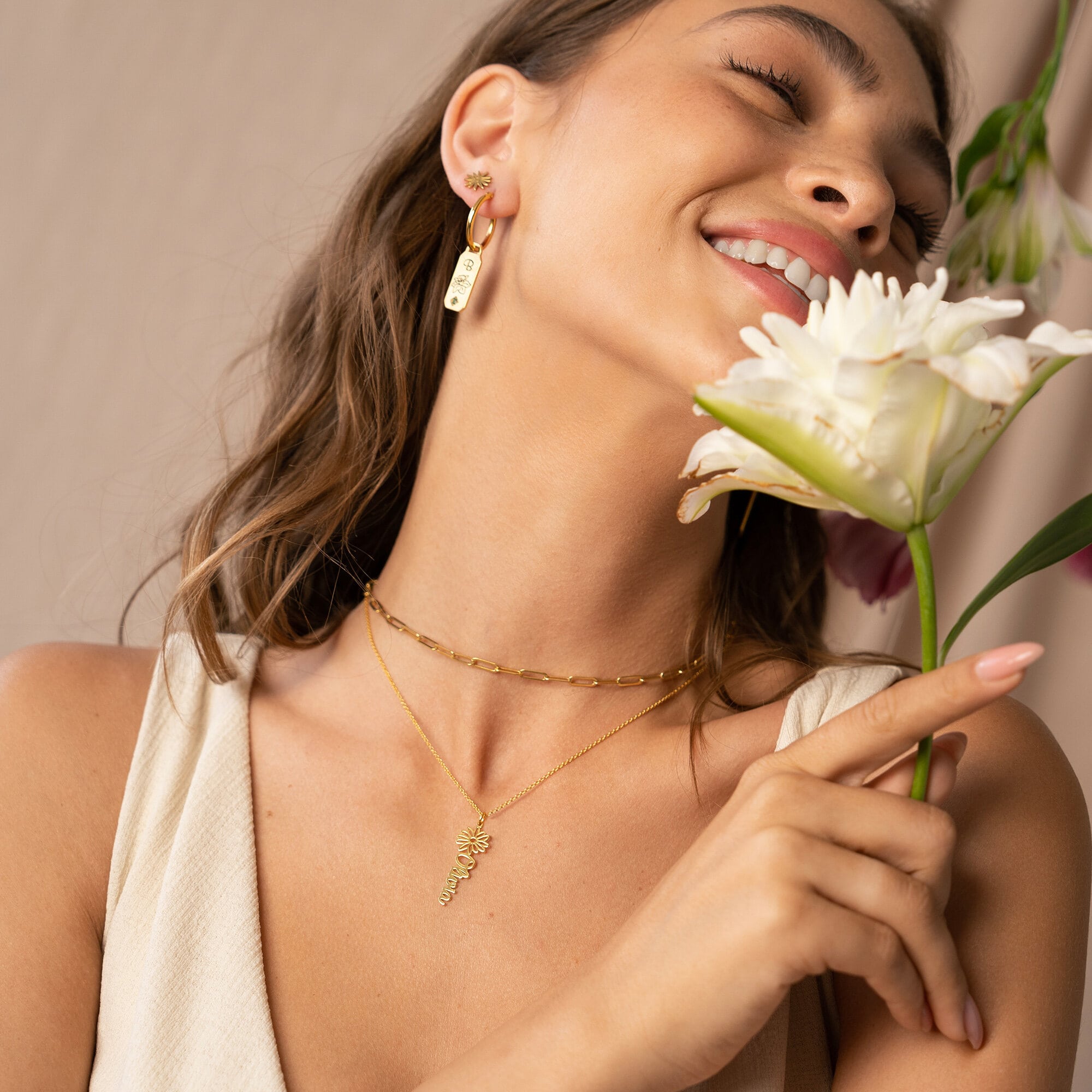 a woman holding a flower in her hand and wearing flower necklace