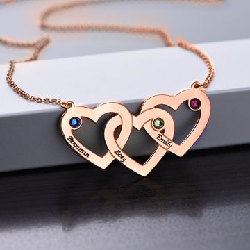 Rose Gold Intertwined Hearts Necklace on a table