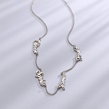 A white gold necklace with multiple names on it