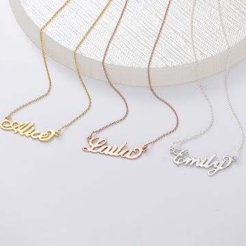 three personalized name necklaces on a white surface
