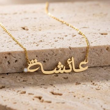 a gold name necklace with arabic Aisha name on it
