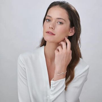 Woman wearing a silver infinity name bracelet with two names in cursive